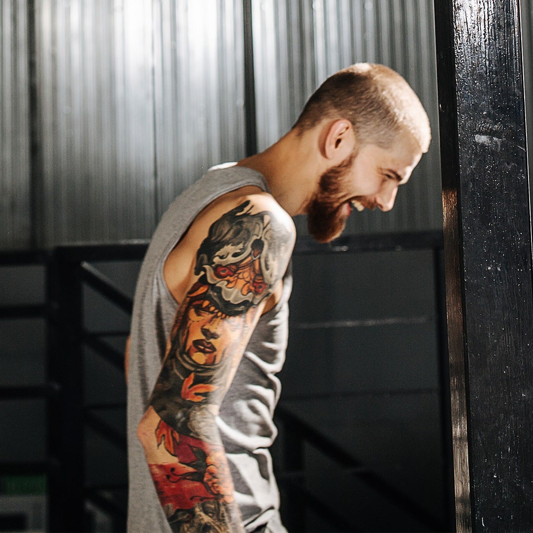 The tattoo features an alpha wolf standing tall and dominant in the center  of the design,